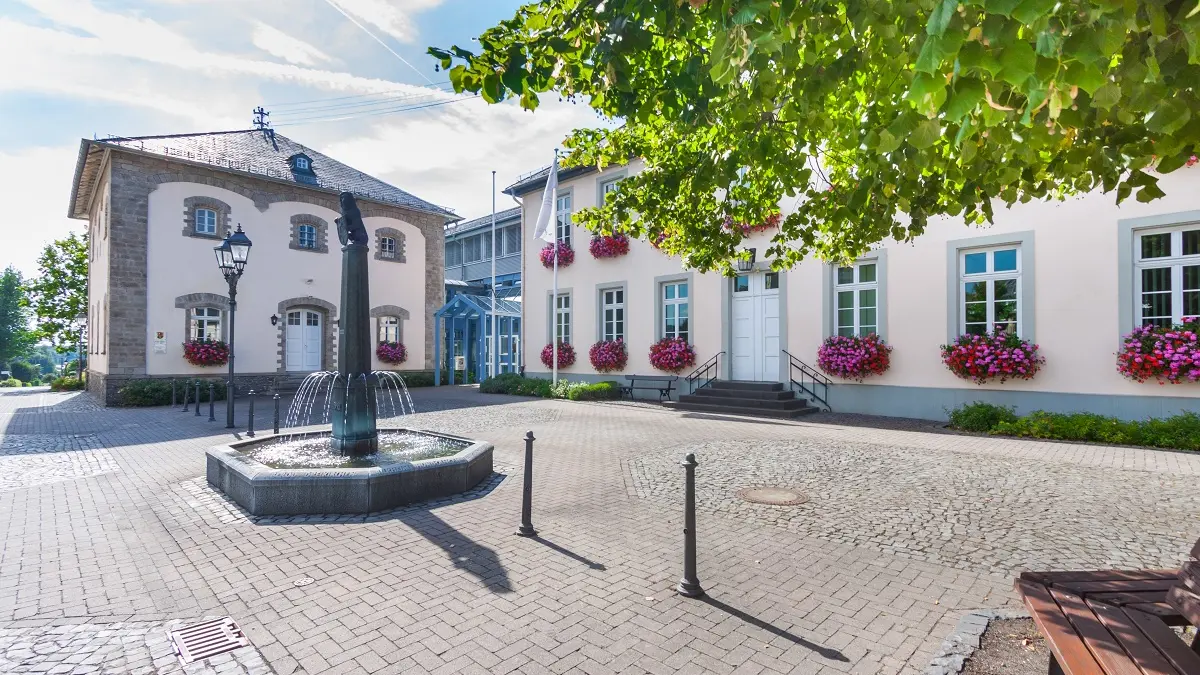 Ein großer Platz mit Häusern udn einem Brunnen in der Mitte.