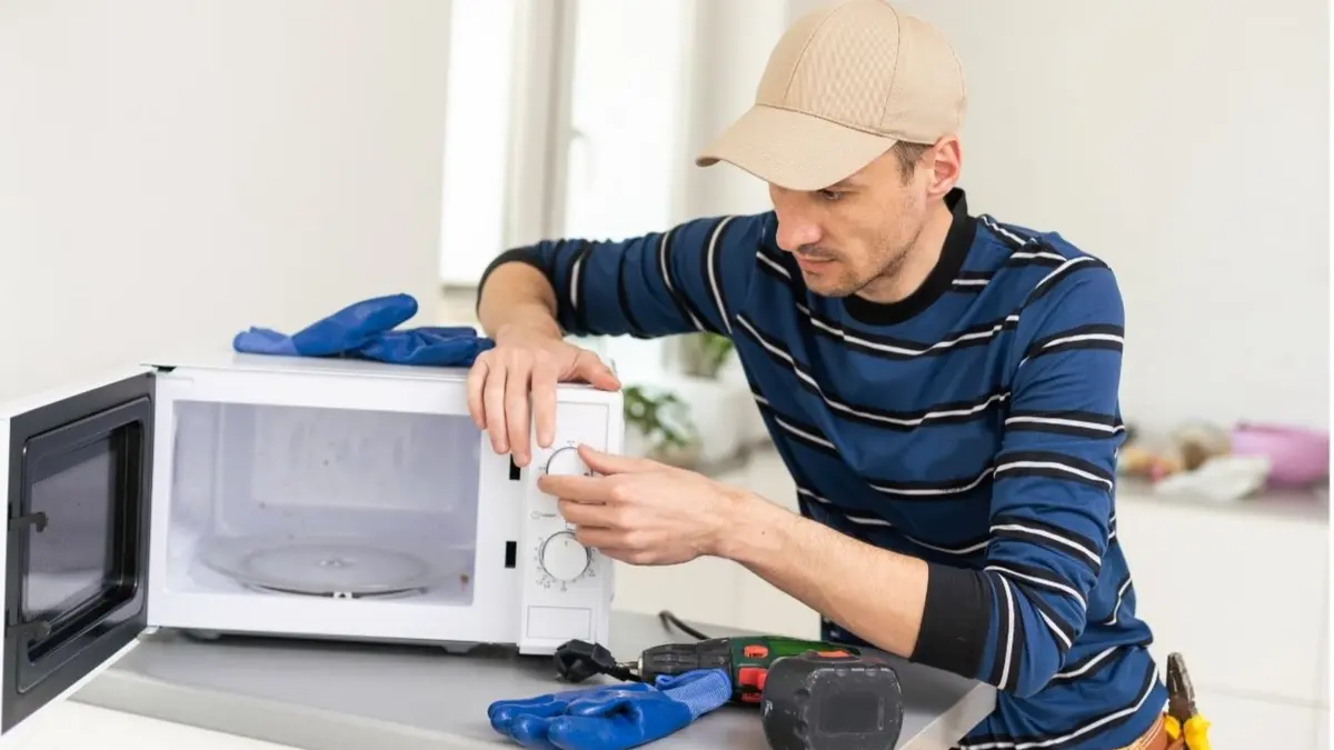 man repairing mikrowave