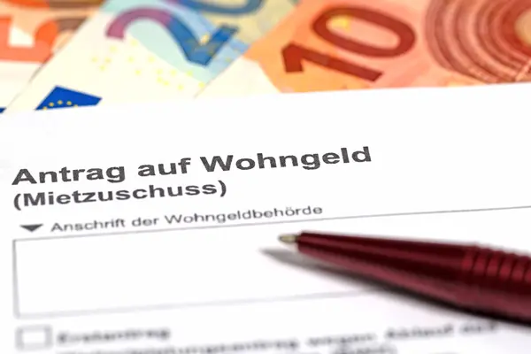 Ein Antrag auf Wohngeld liegt auf einem Tisch, mit mehreren Euro-Scheinen.