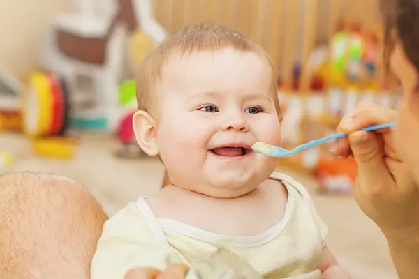 Säugling wird mit Babybrei gefüttert