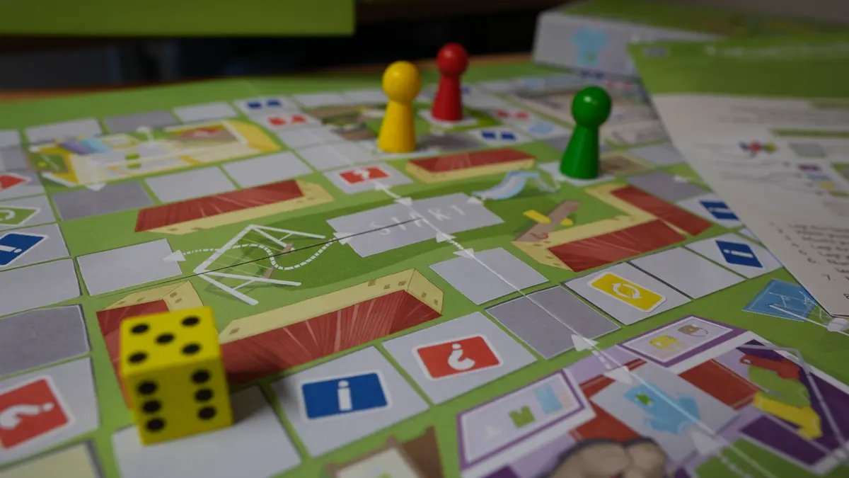 Brettspiel auf dem Spielfiguren und ein Würfel liegen.
