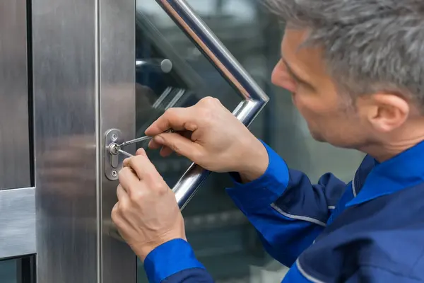 Ein HAndwerker versucht eine Tür zu öffnen.