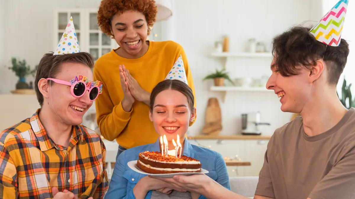 Jugendliche feiern Geburtstag mit einem Kuchen