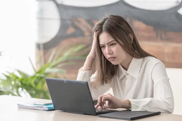 Frau sitzt verärgert vor dem Laptop