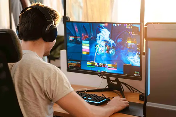 Ein Junge spiel ein Online-Game und hat Headphones auf.