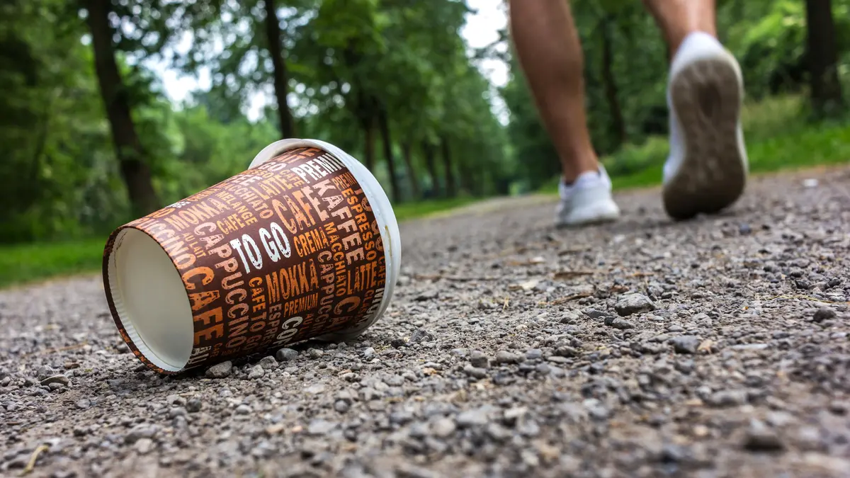 Ein weggeworfener To-go-Becher liegt auf dem Weg