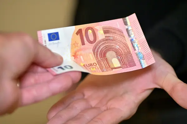 Geldschein geht von Hand zu Hand