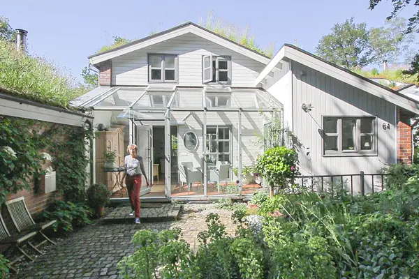 Beispiel Vorgarten mit Frau, die aus Haus kommt