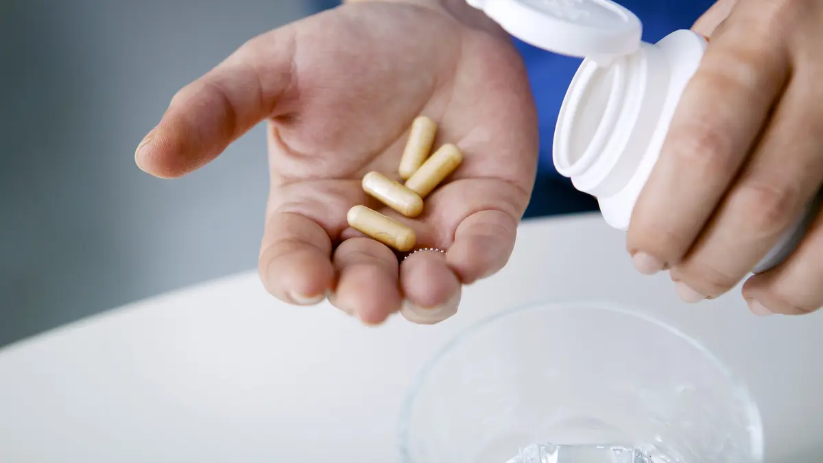 Tabletten für Nahrungsergänzungsmittel auf Handfläche geschüttet