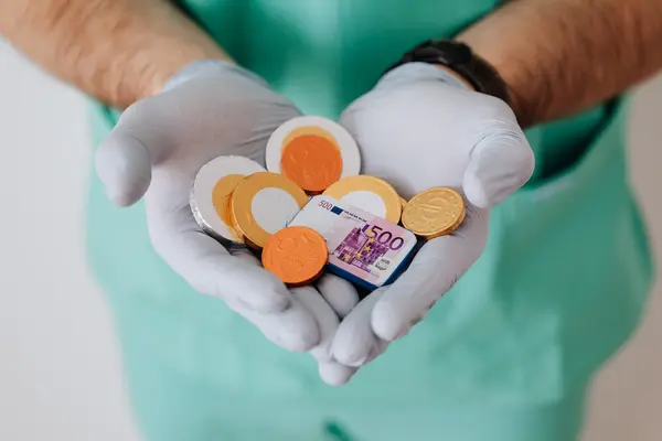 Schokogeld in den Händen von Medpersonal