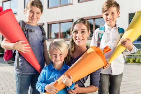 Eine Frau mit drei Schulkindern und ihren Schultüten