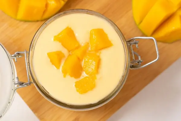 Mangocreme mit Mangostückchen in einem Weckglas