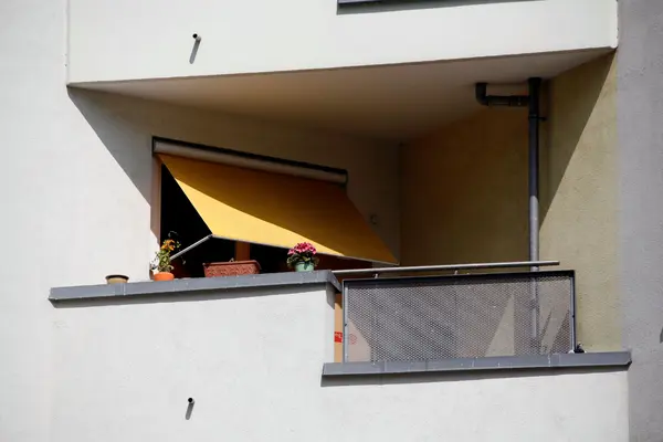 Balkon mit gelber Jalousie