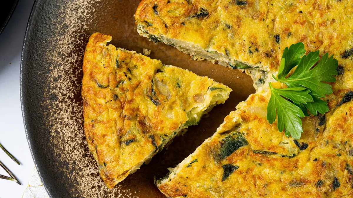 Frittata auf einem Teller, ein Stück ist herausgeschnitten