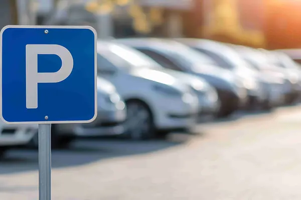 Parkplatzschild im Vordergrund im Hintergrund Autos verschwommen