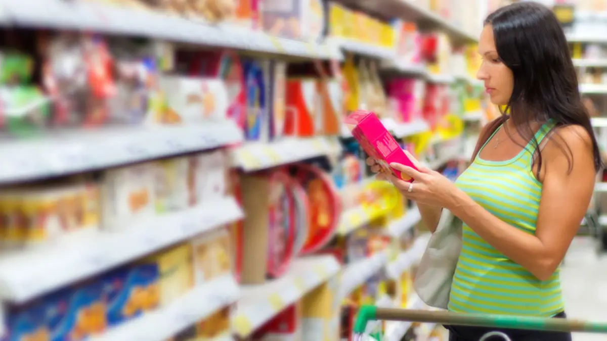 Frau vor Supermarktregal mit Lebensmittelverpackung
