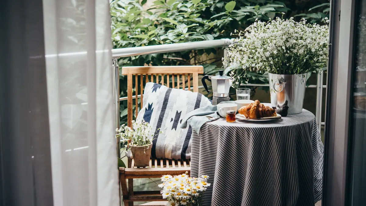 Gemütlicher Balkon mit Pflanzen und Kissen