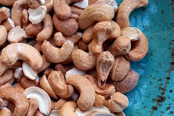 Cashewkerne liegen auf einem blauen Teller.