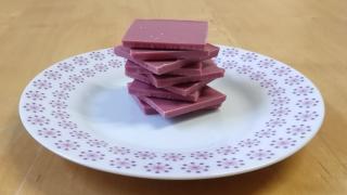 Gestapelte Stückchen Ruby-Schokolade auf einem Teller.