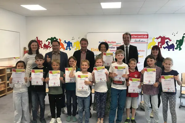 Schüler*innen, Lehrkräfte und Gäste bei der Urkundenübergabe zur nachhaltigen Modellschule in der Regenbogenschule Taucha