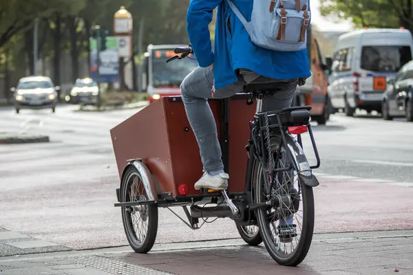 Ein Mann fährt auf einem Lastenfahrrad