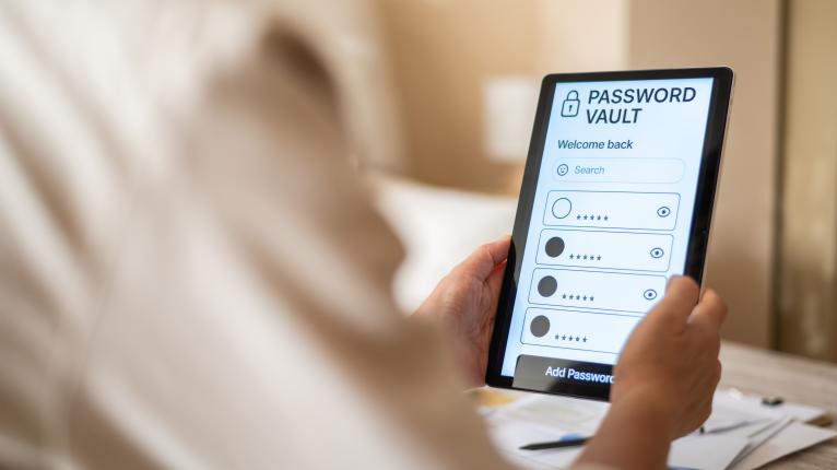Person, die auf einem Tablet auf einen Passwortmanager zugreift.