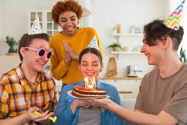 Jugendliche feiern Geburtstag mit einem Kuchen