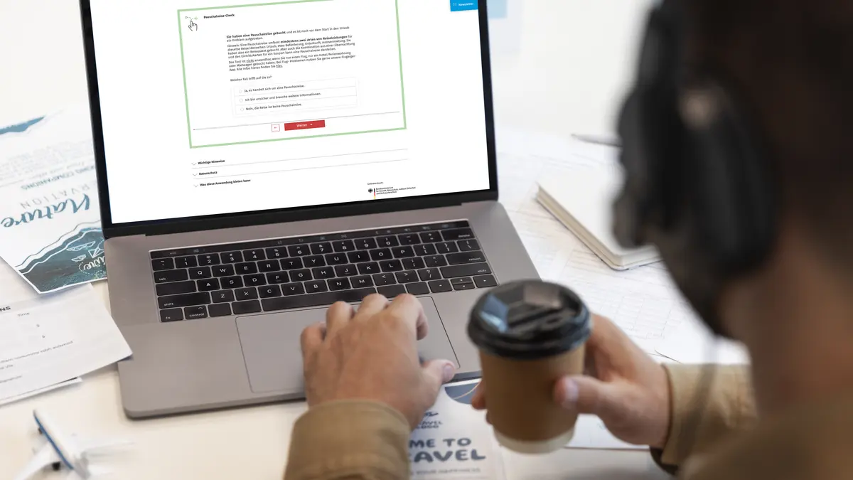 Person schaut online auf die Pauschalreisecheck-Seite