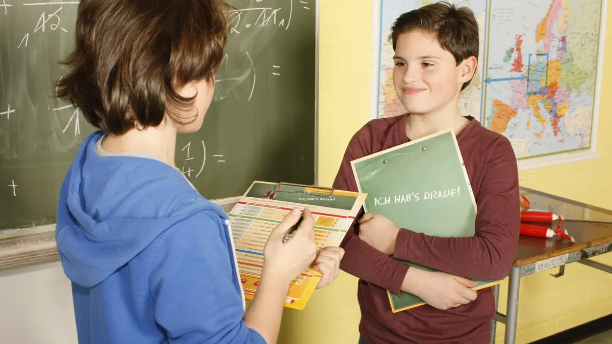 Zwei Kinder sprechen in der Schule miteinander.