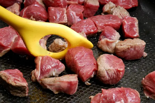 Gulasch wird in einer Pfanne angebraten