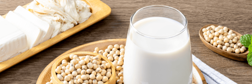 Sojabohnen und Soja-Milch auf einem Tablett auf einem Tisch