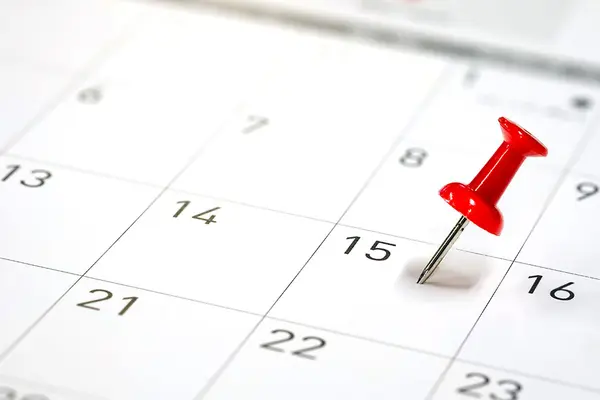 Ein Monatskalender, im 15. steckt ein roter Pin