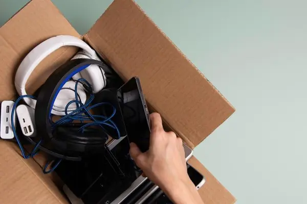 Jemand sucht nach Elektrogeräten in einer Kiste