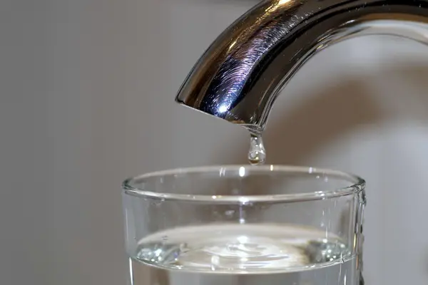 Wasserhahn und Glas