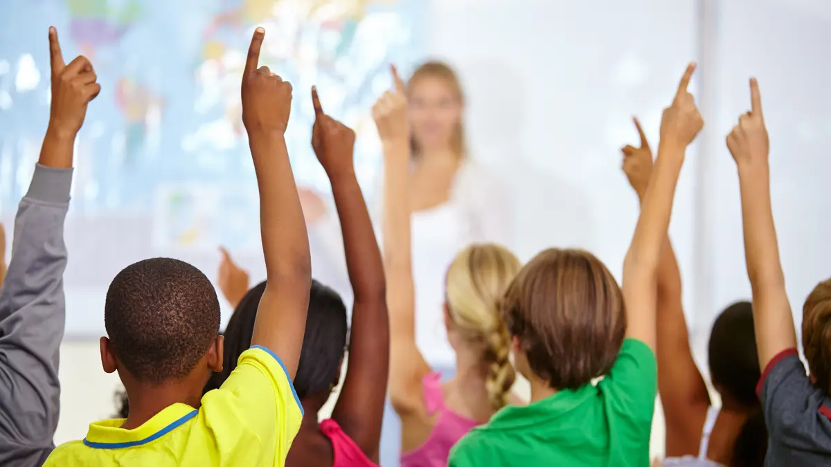 Kinder melden sich in der Schulklasse