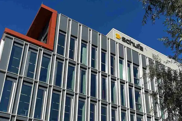 Ein Bürogebäude vom Boden aufwärts fotografiert, am Dach der Schriftzug "schufa"