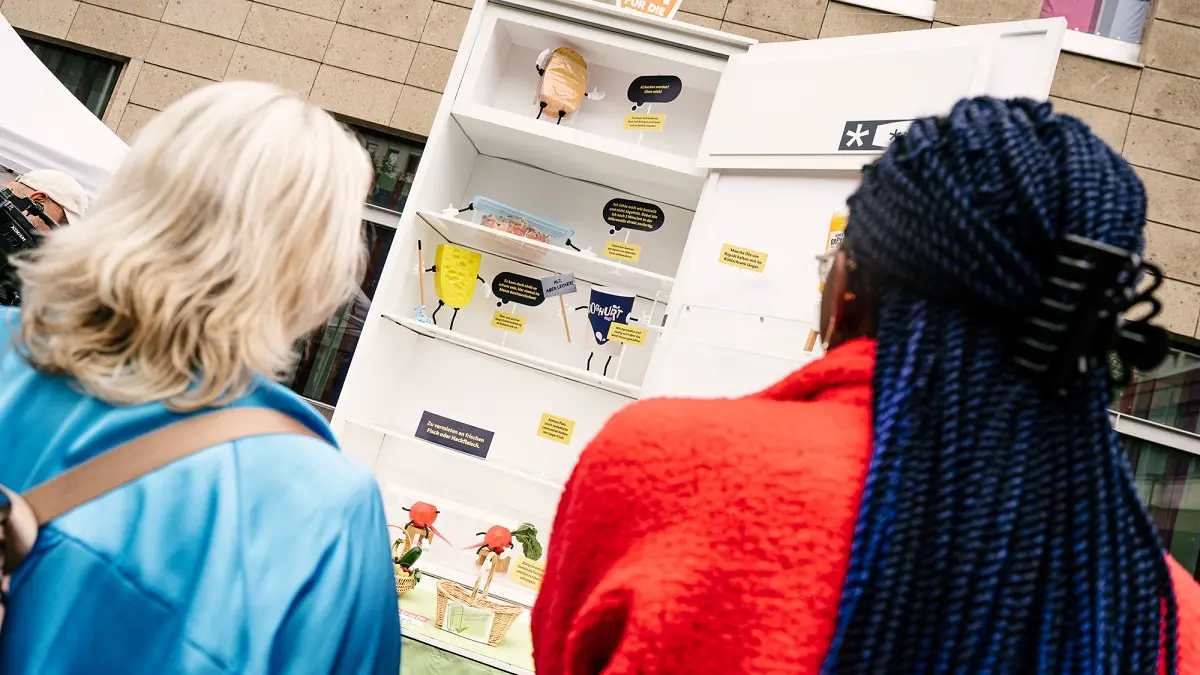 Zwei Frauen von hinten vor einem sehr großem Kühlschrank