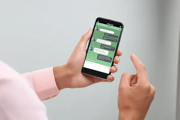 Mann kommuniziert per Messenger auf Smartphone