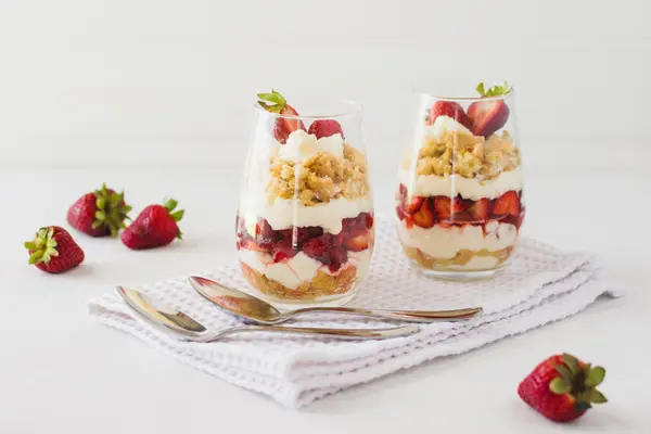 Schichtdessert mit Erdeeren, Joghurt und Keksen im Glas