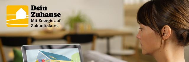 Frau sitzt am Laptop, auf dem ein Haus dargestellt wird