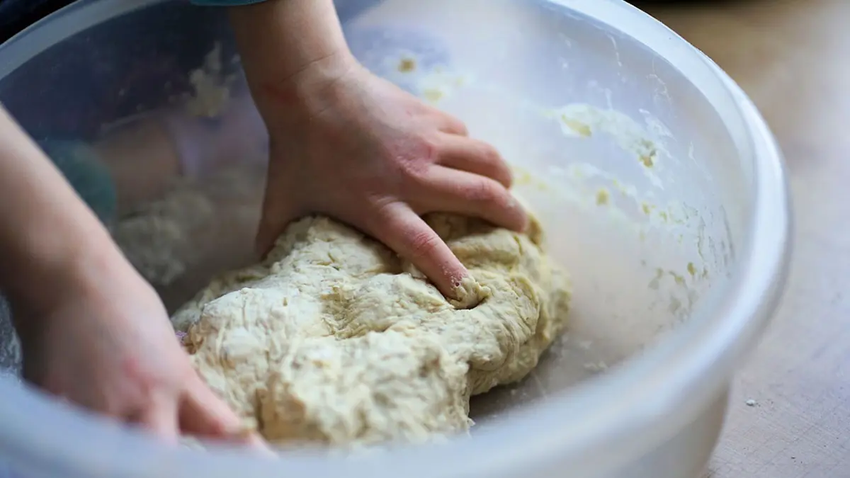Kinderhände kneten Teig in einer Schüssel