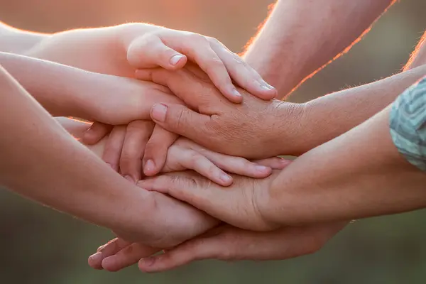 Mehrere Menschen haben ihre Hände übereinandergelegt