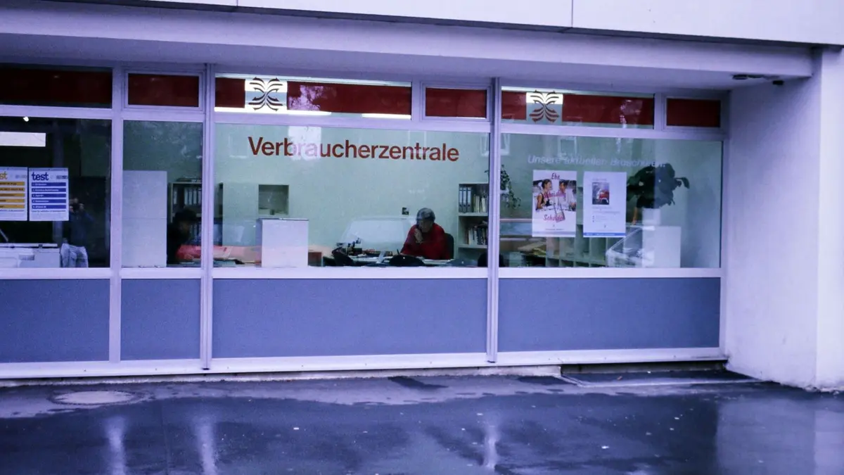 Eine Frau telefoniert hinter einer Schaufensterscheibe
