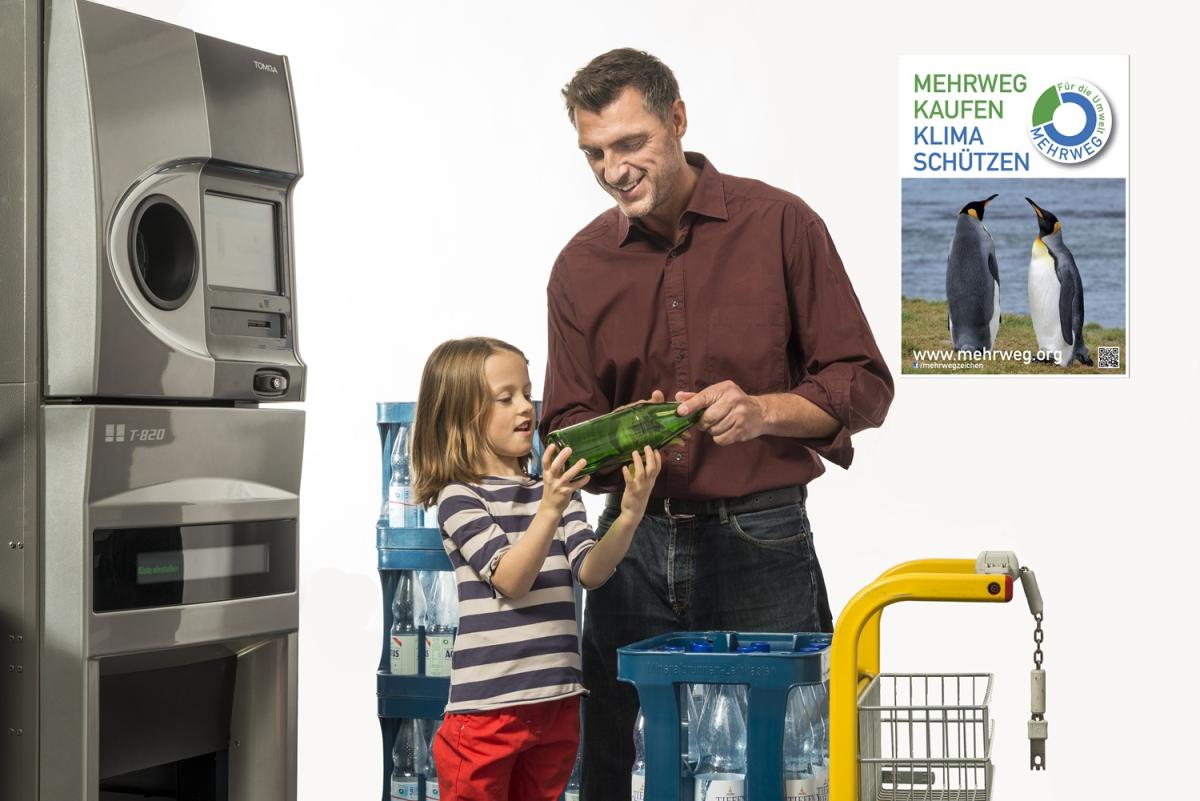 Mann mit Kind gibt Pfandflaschen am Automat zurück