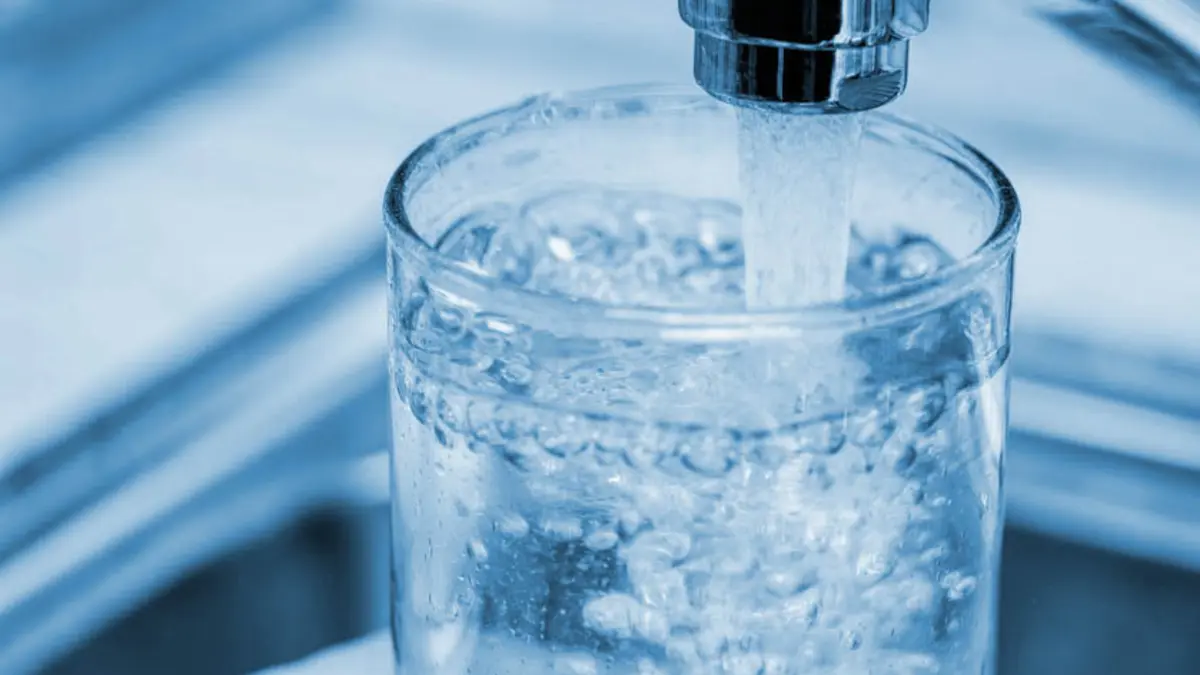 Glas unetr laufendem Wasserhahn