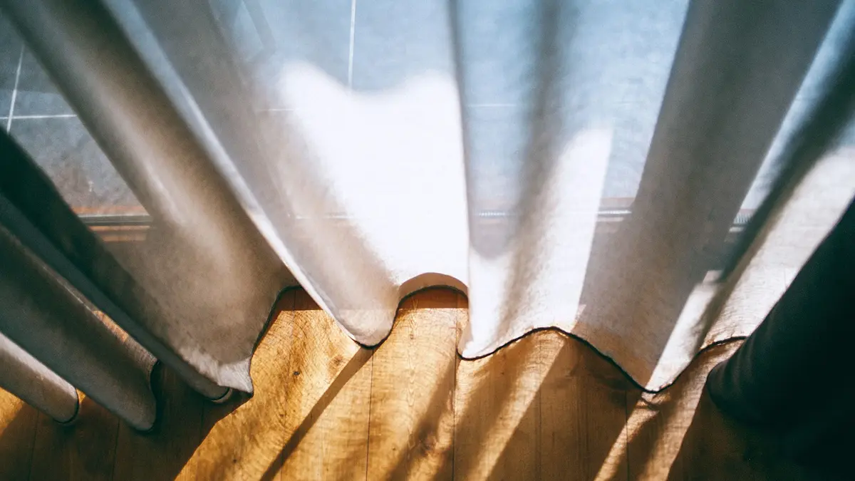Fenster, Vorhänge und Boden im Sonnenlicht