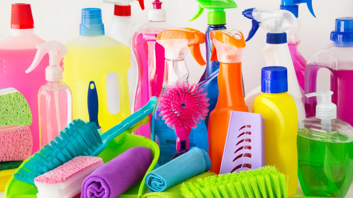 Diverse bunte Putzmittel, Haushaltsreiniger, Bürsten, Schwämme und Tücher