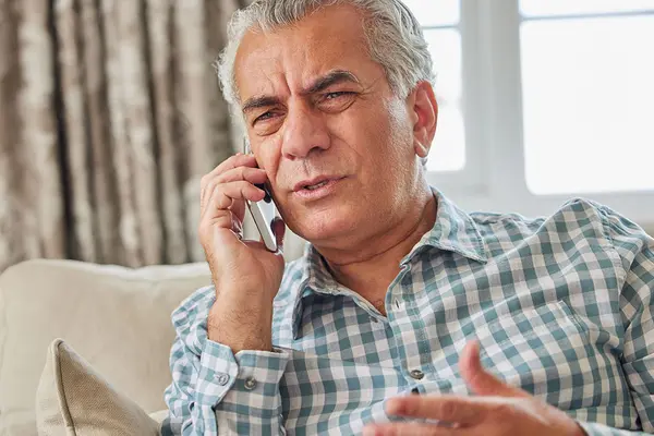 Ein älterer Mann verärgert am Telefon