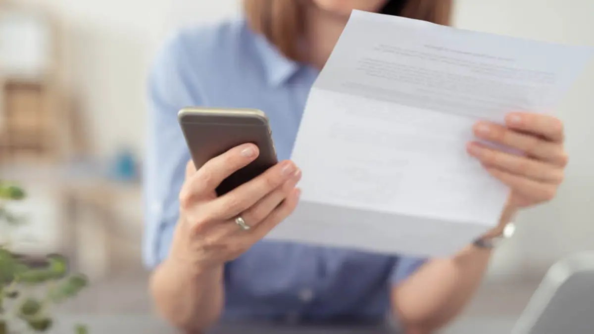 Frau mit Smartphone und Vertrag