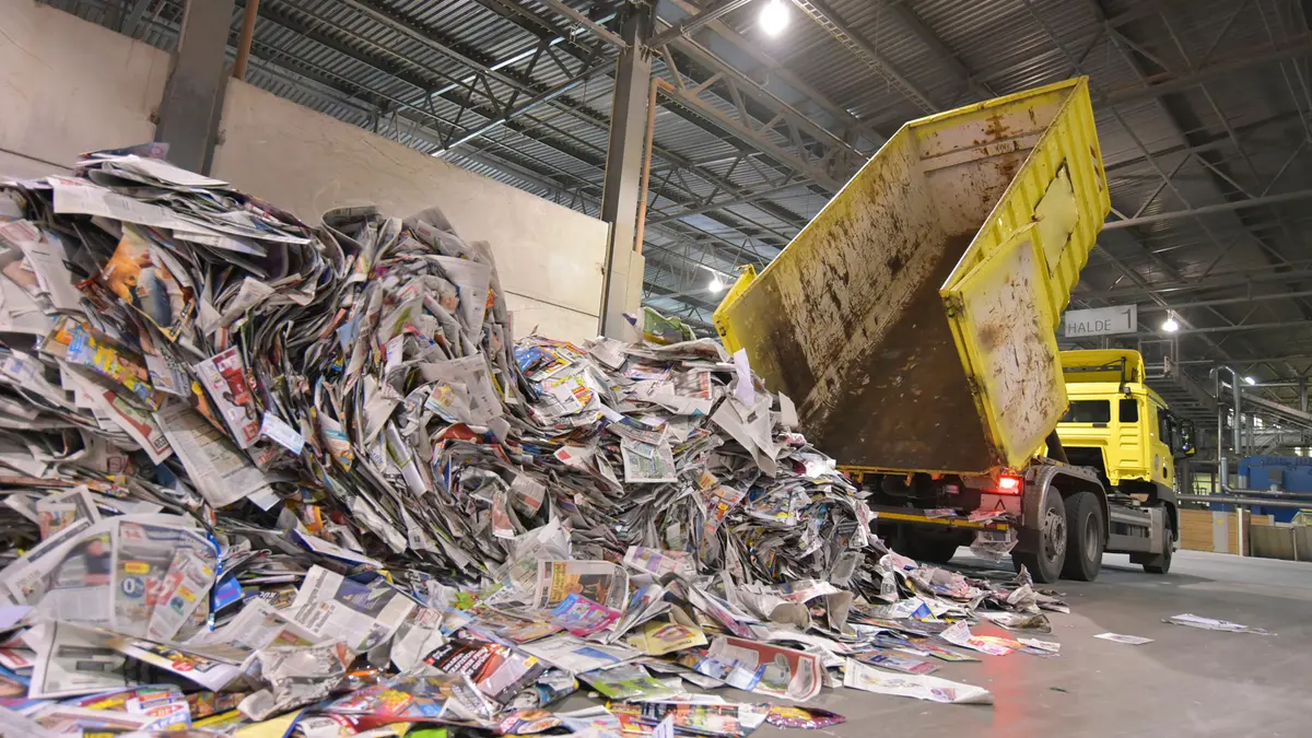 Ein Kipplader schüttet eine Menge Altpapier aus.